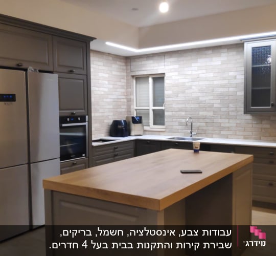 מטבח משופץ עם ארונות אפורים ומשטח עץ